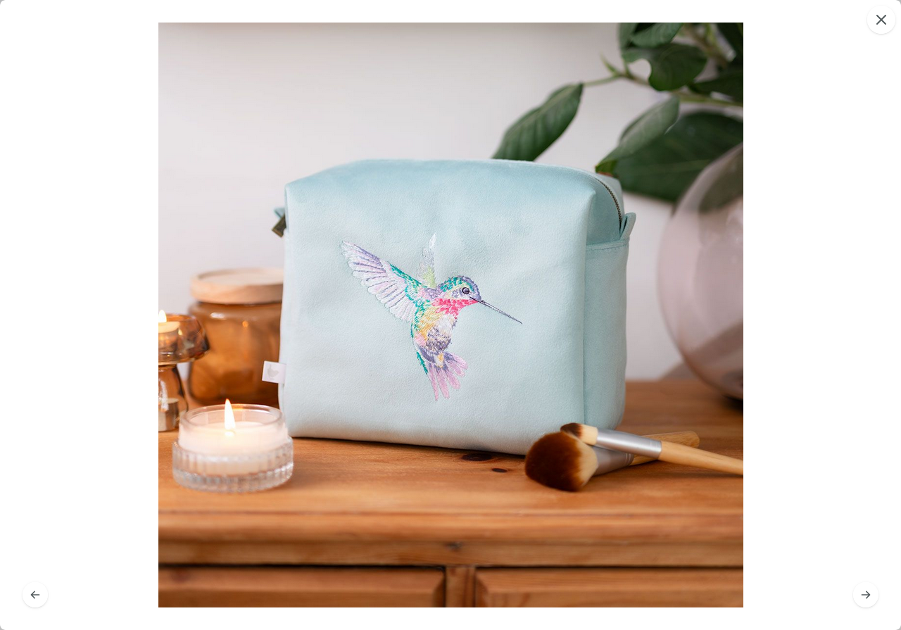„Geräumige Kosmetiktasche mit sicherem Reißverschluss und floralem Wisteria-Wishes-Stickdesign.“
